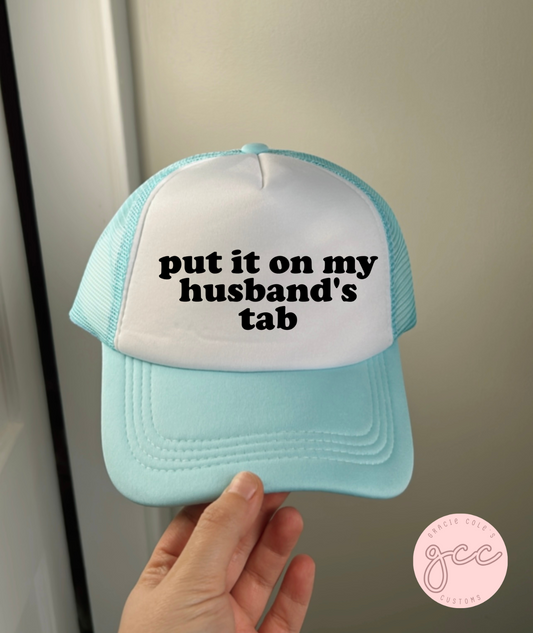 Put It On My Husbands Tab Trucker Hat